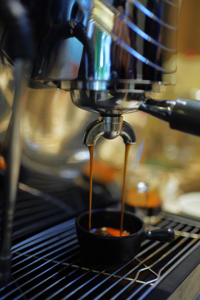 Professional cafe barista pulling a perfect espresso shot